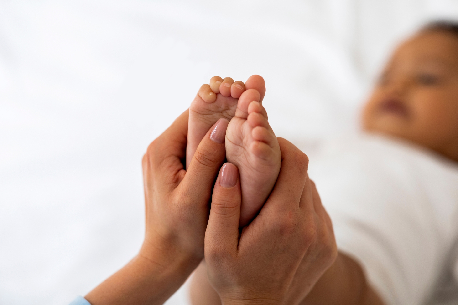 Massage des pieds d'un bébé par sa maman
