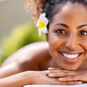 Une femme souriant se faisant masser le dos