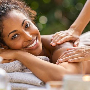 Une femme souriante se faisant masser le dos